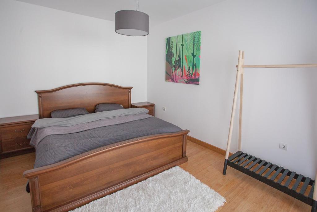 Helles Schlafzimmer mit Doppelbett in einer Wohnung in Budva, Montenegro: Holzmöbel und Laminatboden.