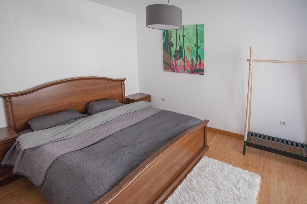 Schlafzimmer in einer Wohnung in Budva, Montenegro: Doppelbett aus Holz, Garderobenständer und helles Interieur.