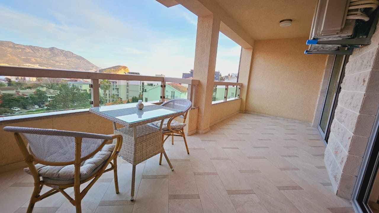 Geräumiger Balkon mit Rattanmöbeln und Bergblick in einer Wohnung, Budva, Montenegro.