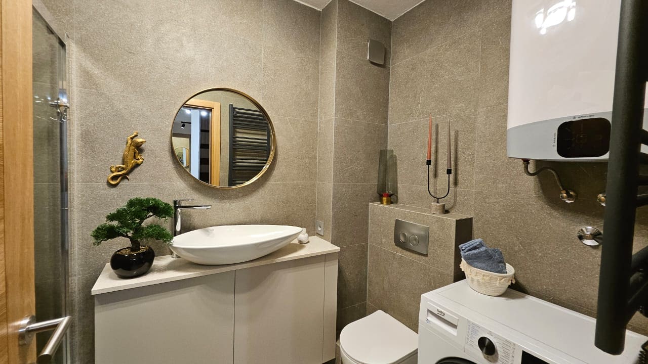 Modernes Badezimmer in einer Wohnung in Budva, Montenegro: stilvolle Ausstattung, Aufsatzwaschbecken und Waschmaschine.