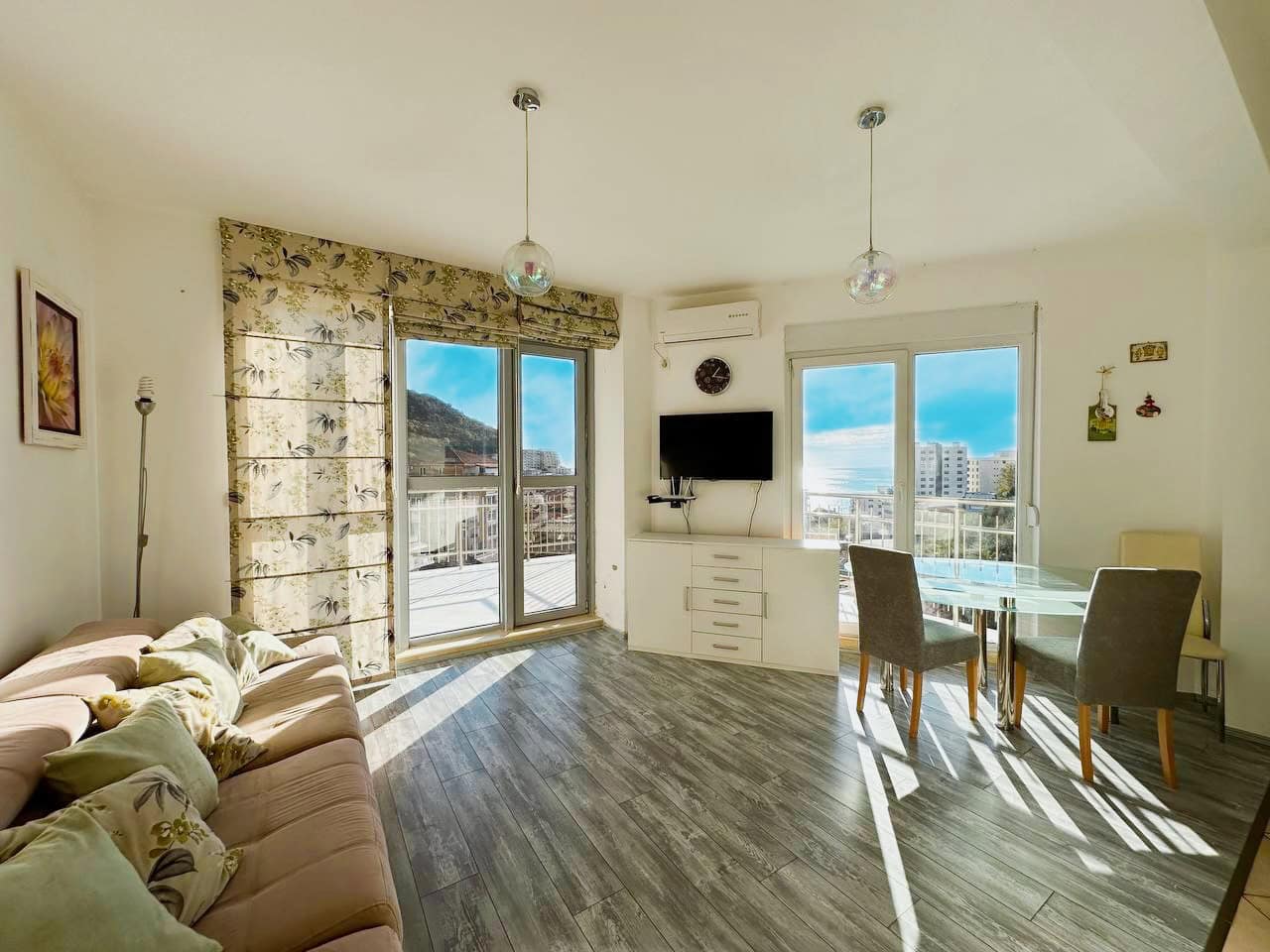 Helles Wohnzimmer mit Panoramafenstern und Meerblick in einer Wohnung, Bečići, Montenegro. Moderne Möbel und Ausstattung.