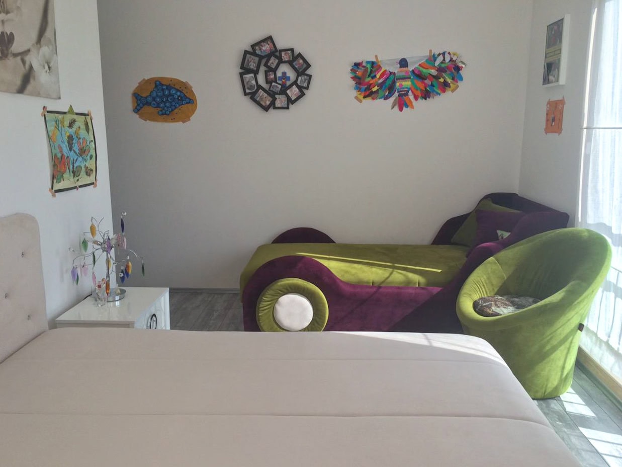 Kinderzimmer in einer Wohnung in Bečići, Montenegro: heller Raum mit Betten, Sessel und Wanddekoration.