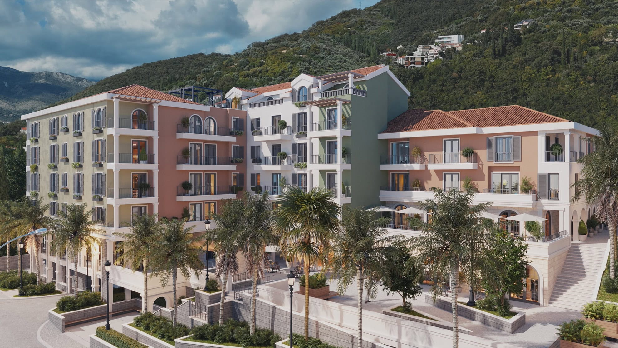 Tivat, Karadağ'da teraslı ve palmiye ağaçlı modern konut kompleksi: Dağların eteğindeki lüks binanın dış cephe görünümü.