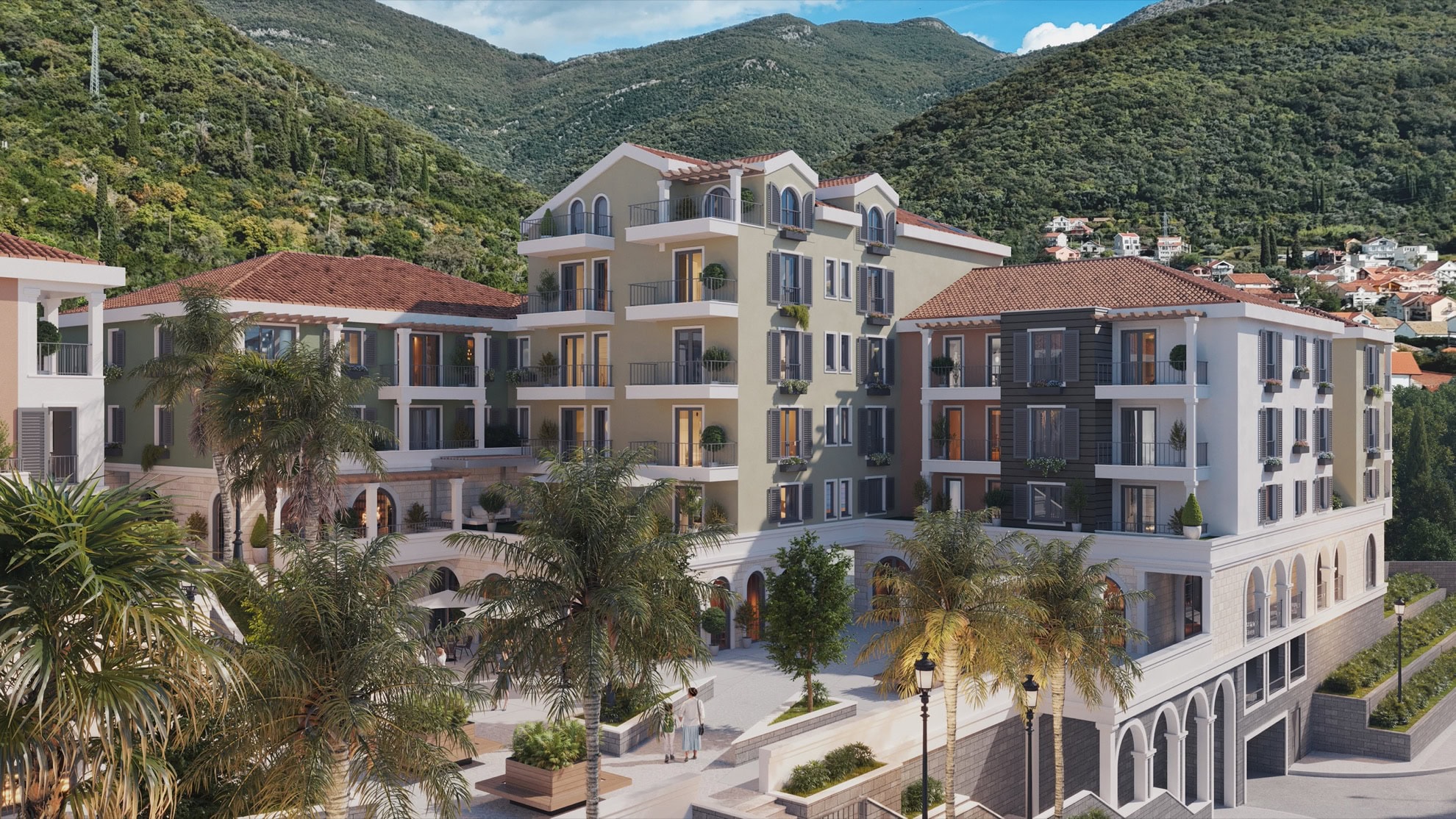 Tivat, Karadağ'da teraslı ve palmiye ağaçlı modern konut kompleksi: dağ manzaralı bina cephesi görünümü.