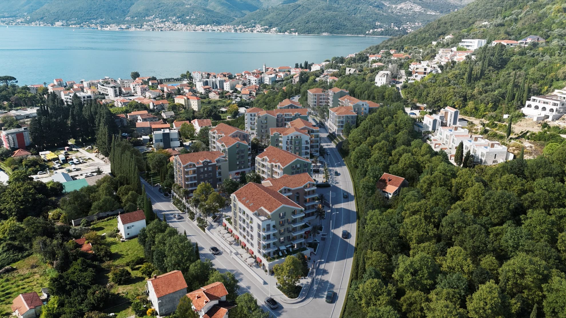 Karadağ, Tivat'taki konut kompleksinin havadan görünümü: Deniz ve dağlar kıyısında, kiremit çatılı modern evler.