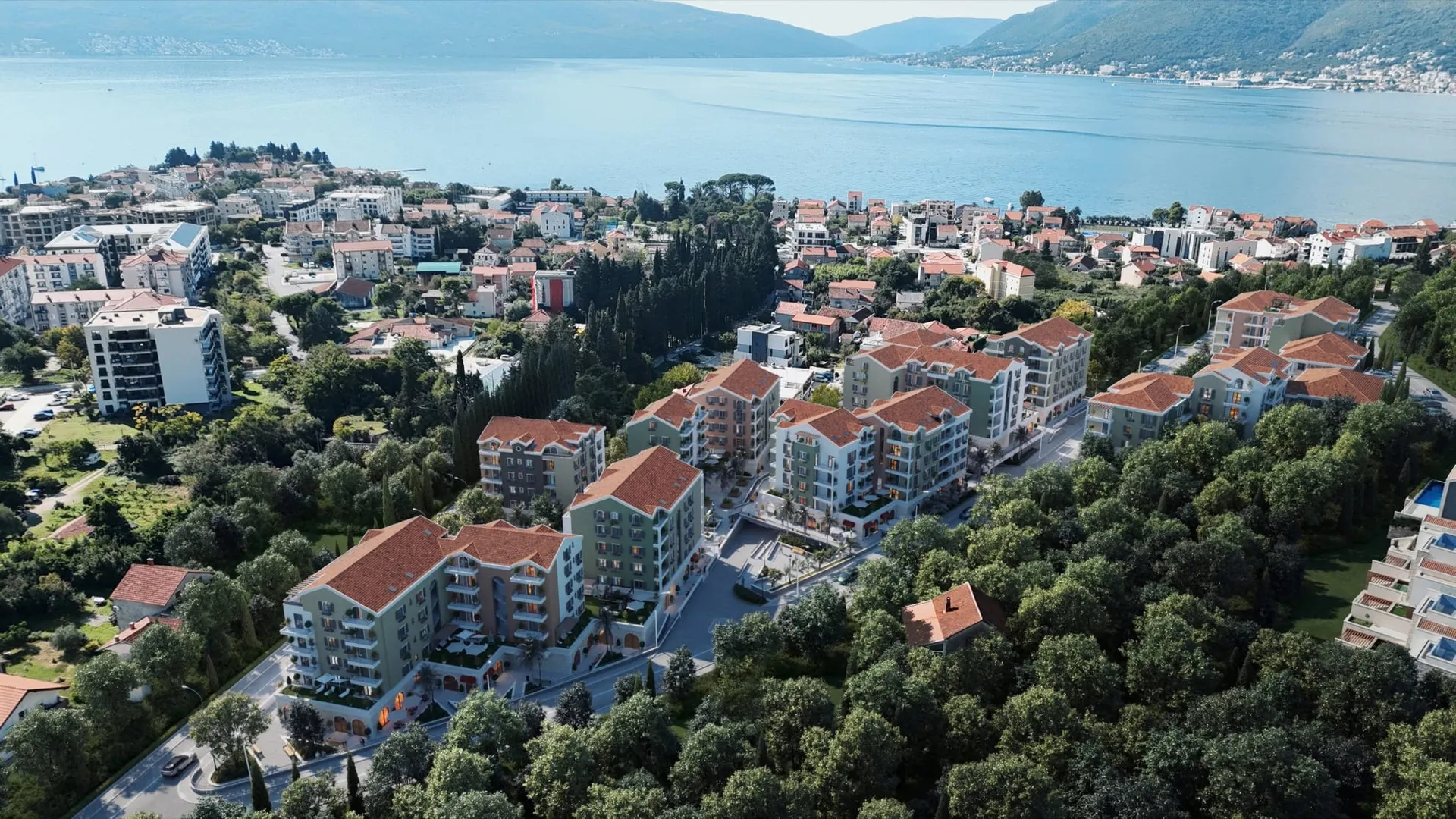Arka planda deniz ve modern binaların yer aldığı sahil beldesinin havadan görünümü.