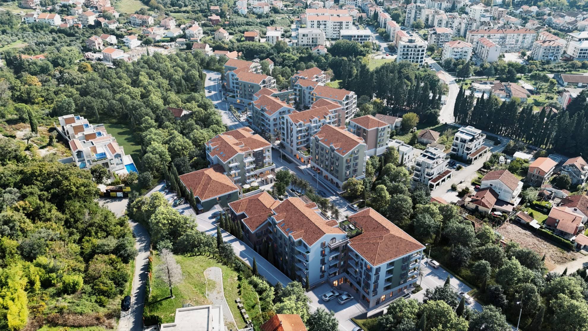 Tivat, Karadağ'da yeşillikler içinde, kiremit çatılı konut kompleksinin havadan görünümü.
