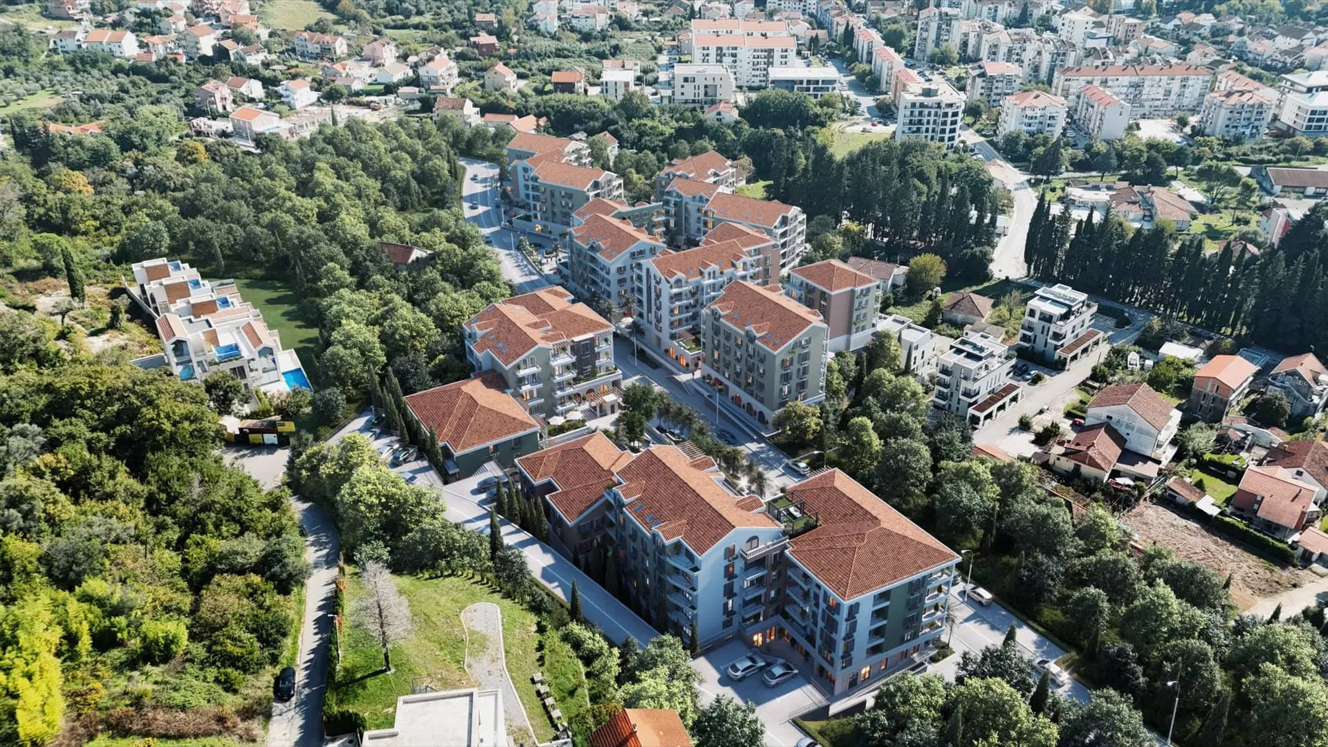 Yeşillikler arasında kiremit çatılı modern konut binalarının havadan görünümü