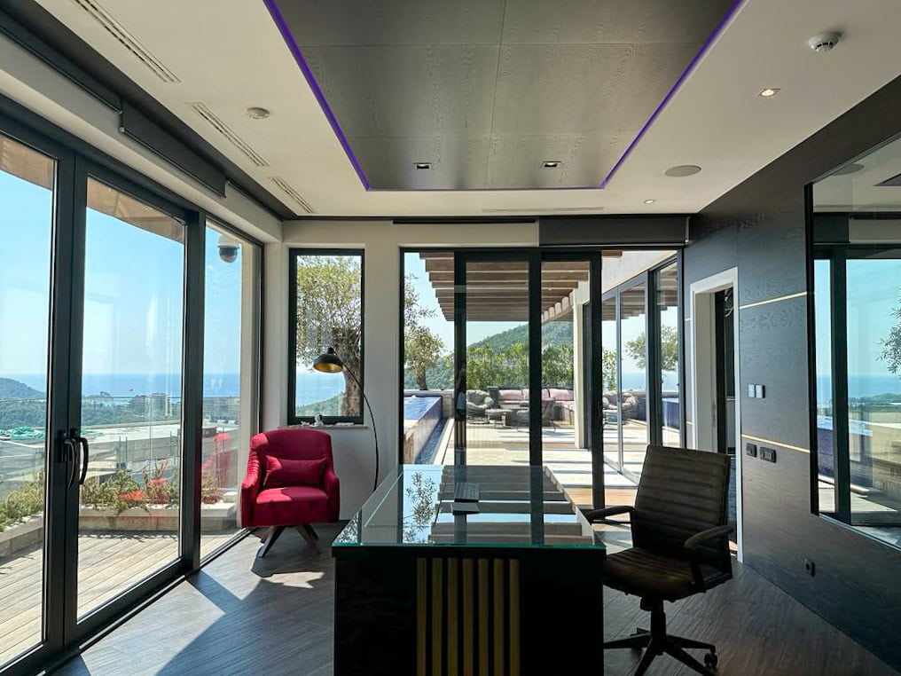 Modernes Arbeitszimmer im Penthouse in Bečići, Montenegro: Glastisch, Panoramafenster mit Blick auf das Meer und die Terrasse.