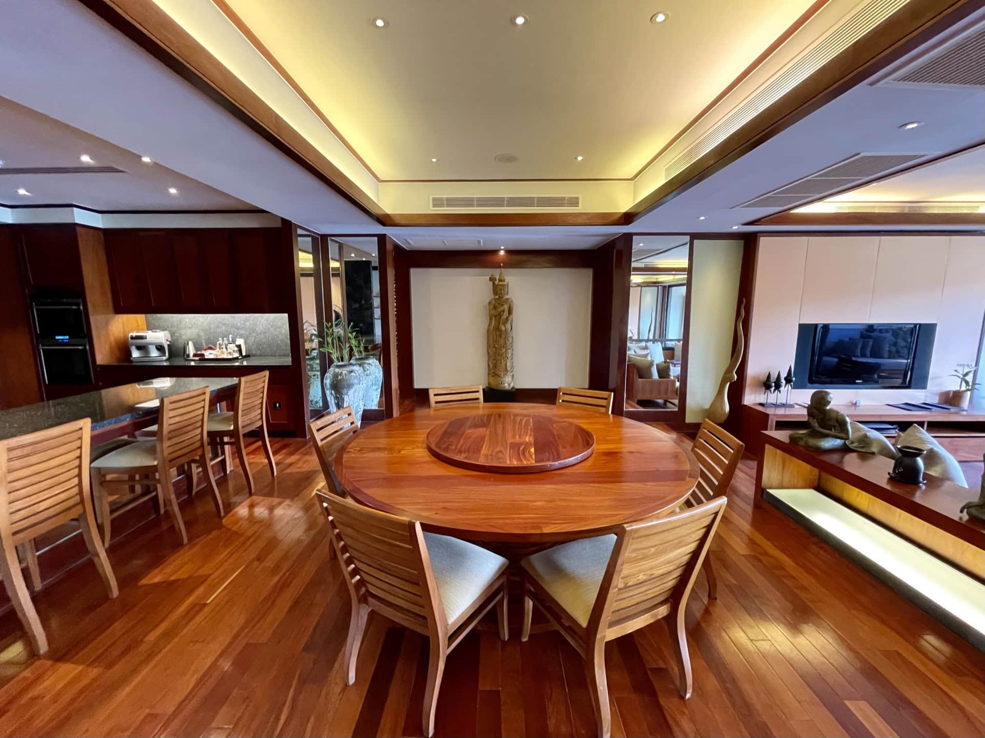 Luxuriöses Wohnzimmer mit Essbereich, Holzmöbeln und ethnischer Dekoration in exklusiven Apartments auf Phuket