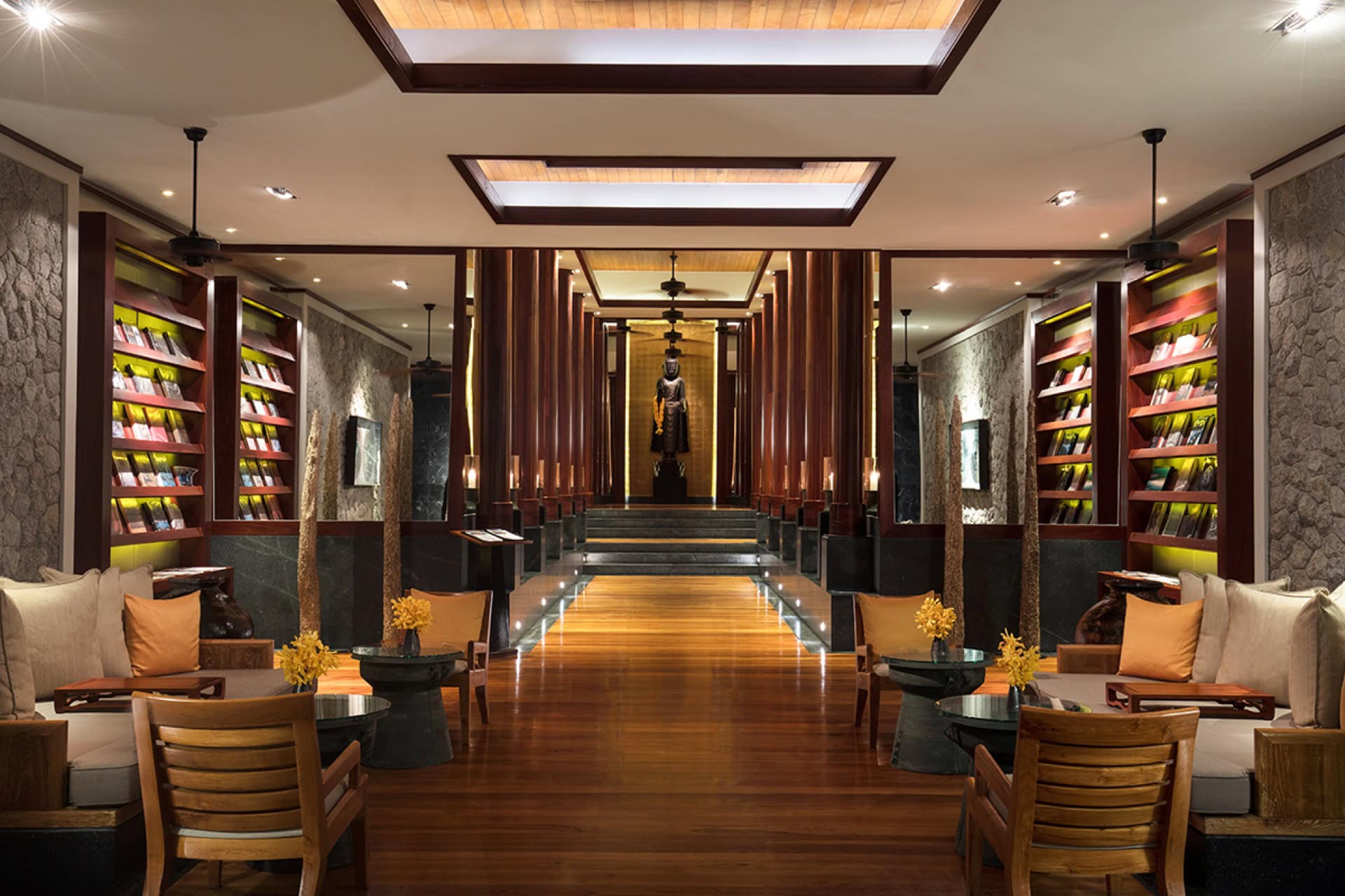 Luxuriöses Hotellobby-Interieur in Montenegro: Holzverkleidung, Bücherregale und eine Statue in der Mitte des Saals.