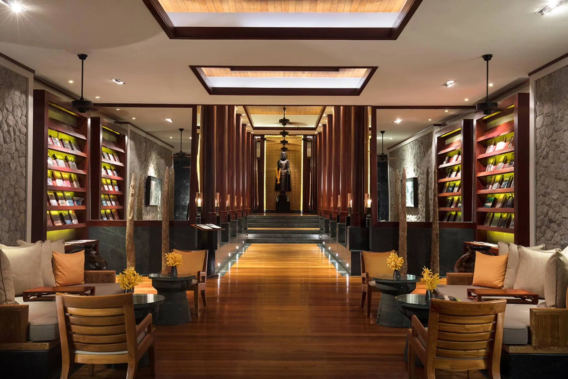 Luxuriöses Hotellobby-Interieur in Montenegro: Holzverkleidung, Bücherregale und eine Statue in der Mitte des Saals.