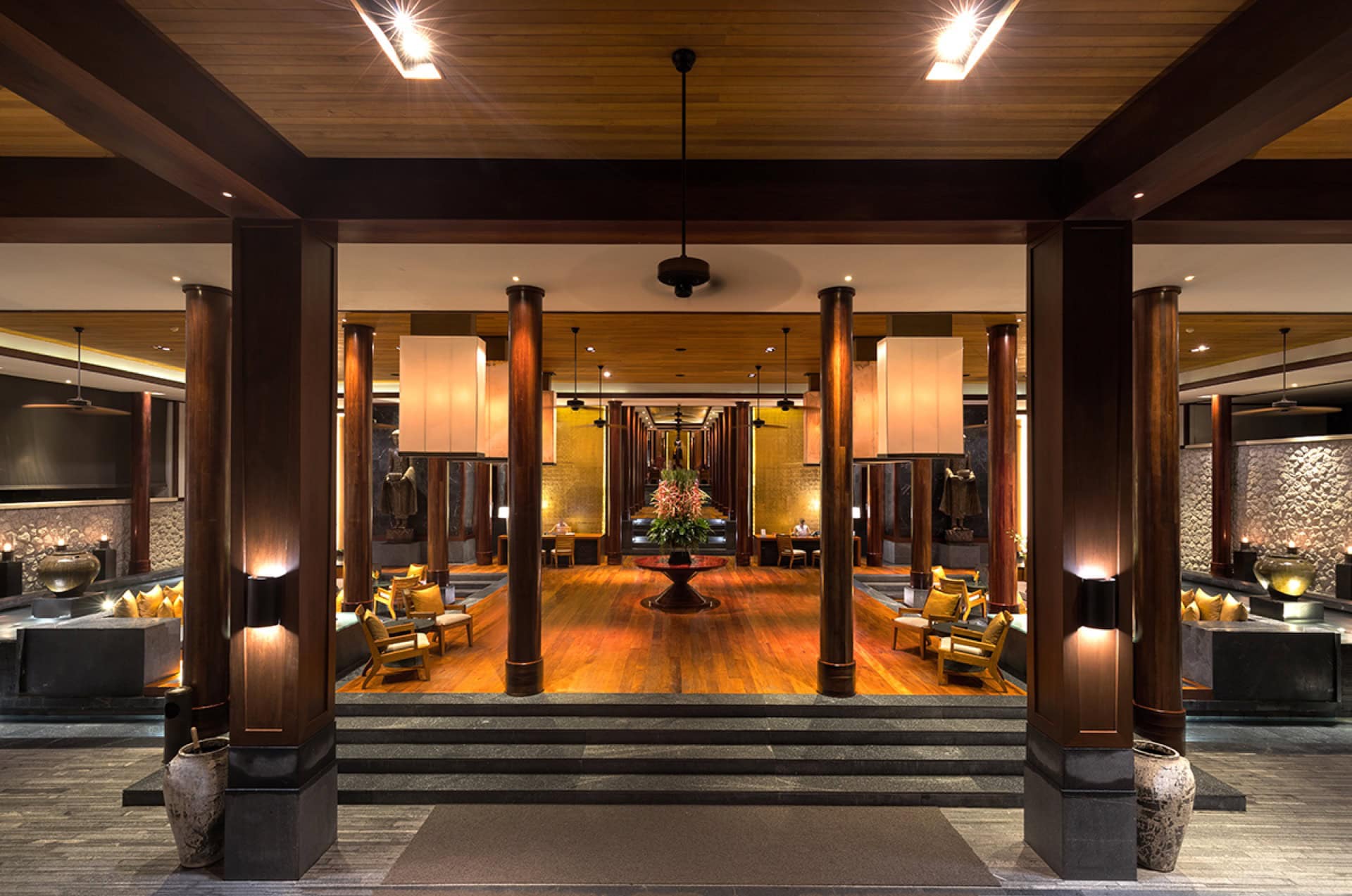 Luxuriöses Hotellobby-Interieur auf Phuket: Holzverkleidung, Säulen, weiche Sitzmöbel und stilvolle Beleuchtung in Thailand