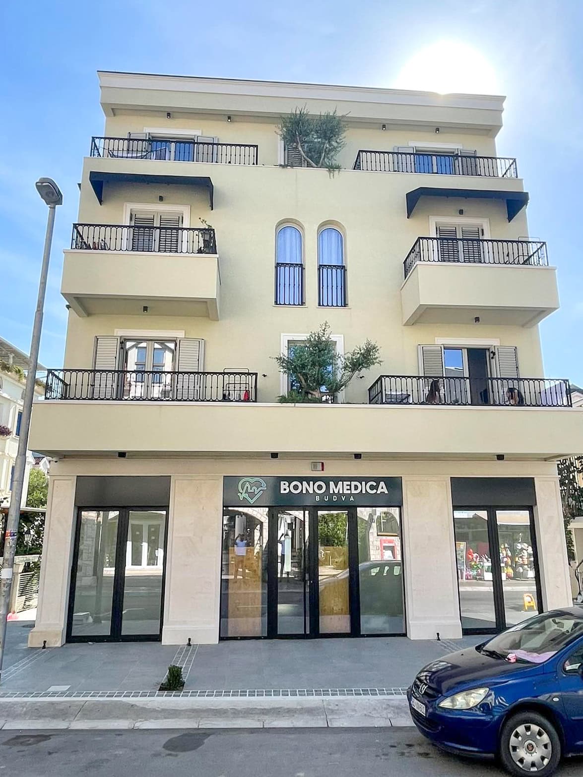 Karadağ, Budva’daki Bono Medica ticari alanına sahip modern konut binasının cephesi, balkonlar ve teraslarla.