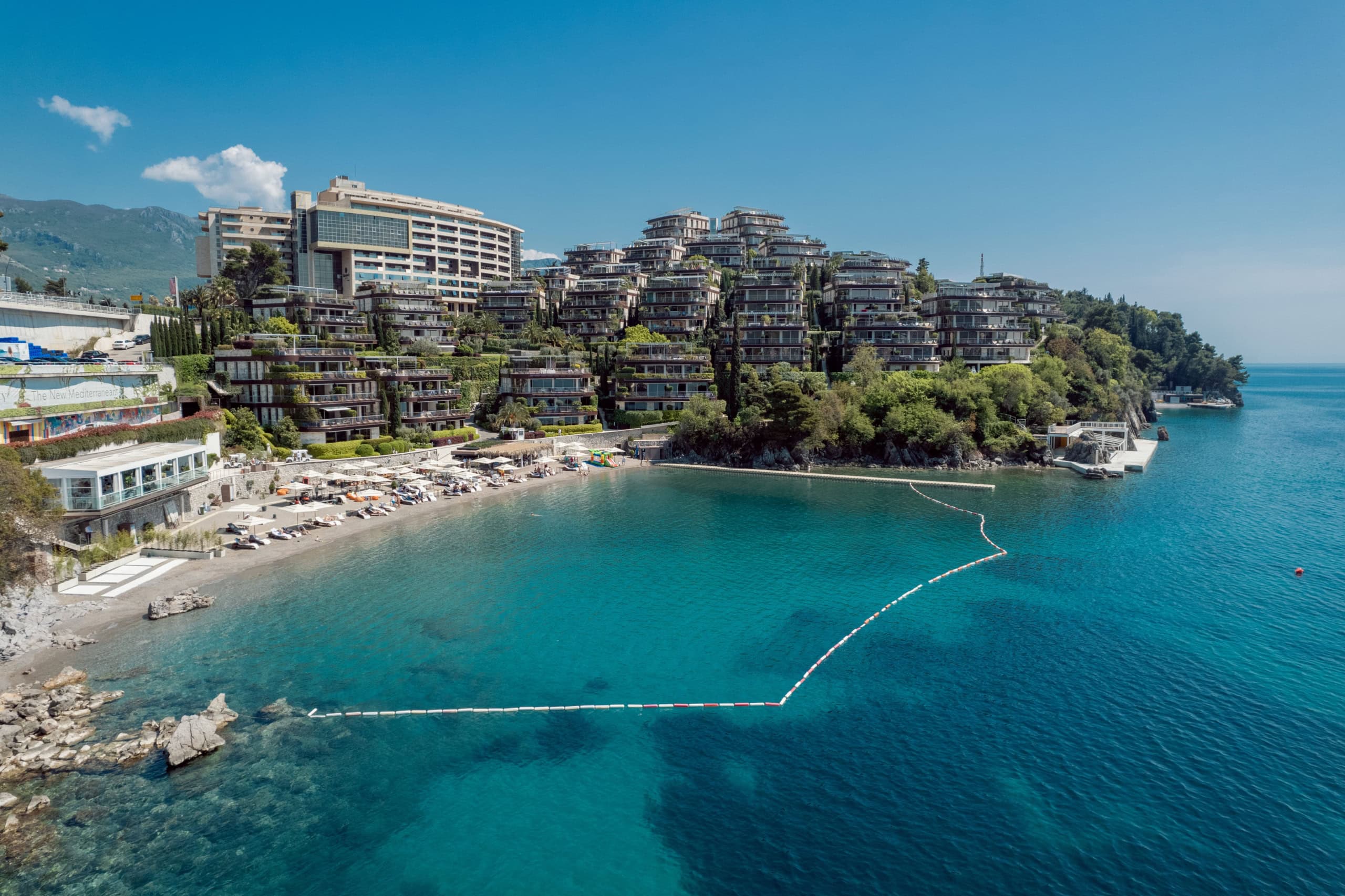 Luftaufnahme des exklusiven Wohnkomplexes Dukley Gardens in Budva, Montenegro, mit Privatstrand und azurblauem Meer.