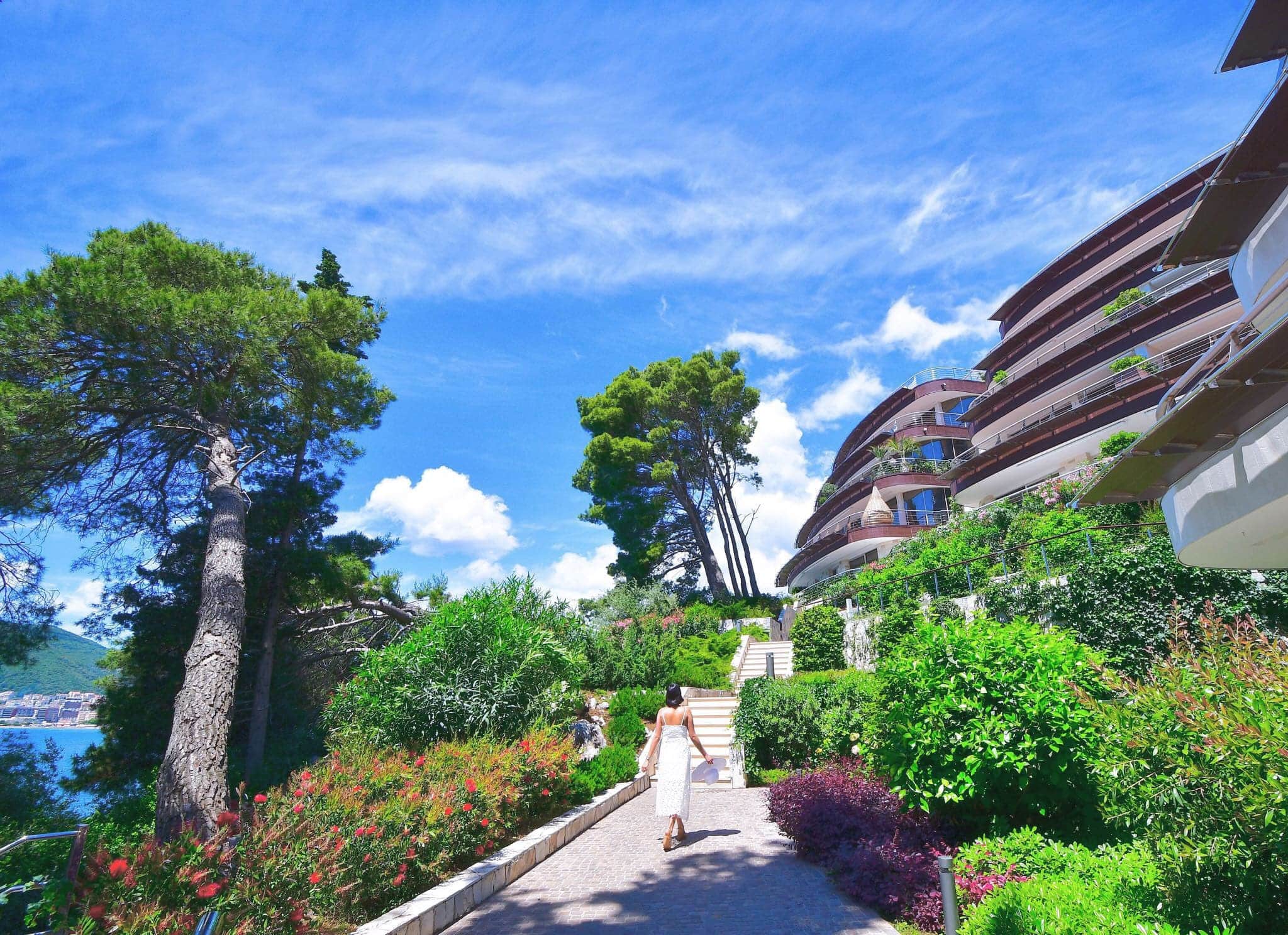 Moderner Wohnkomplex in Budva, Montenegro: gepflegtes Gelände mit Garten und Wegen zum Meer.
