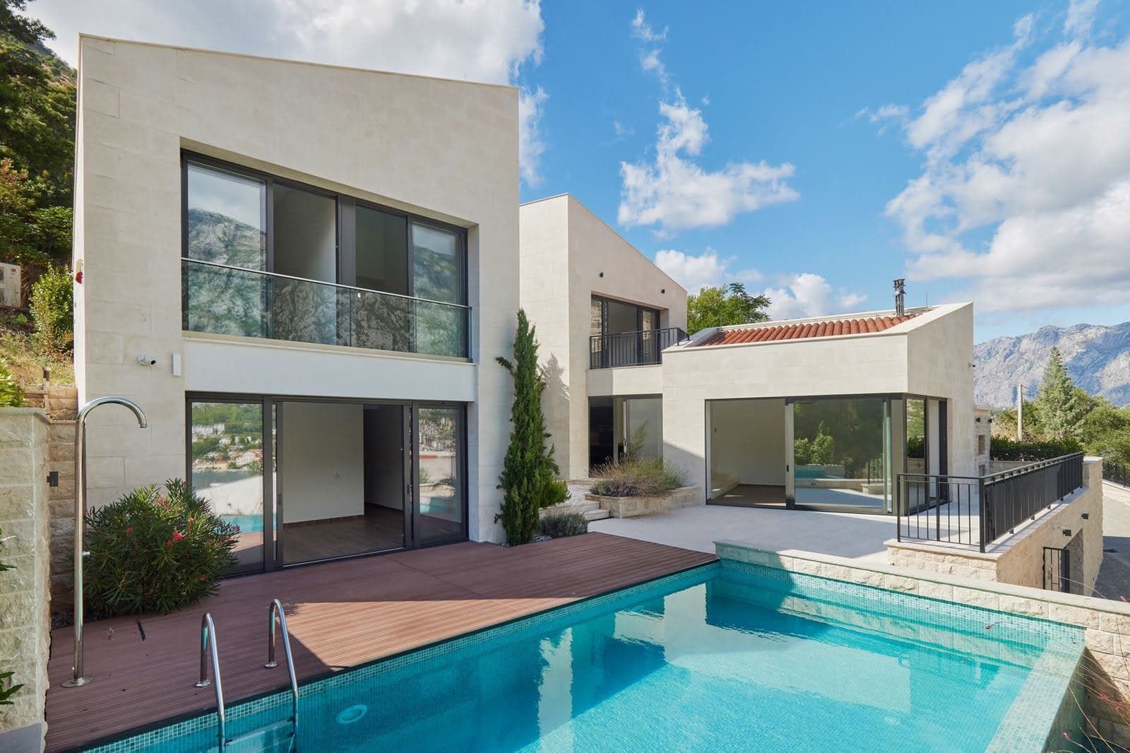 Prčanj, Karadağ’da havuzlu ve teraslı modern villa: panoramik pencereler, taş kaplama ve dağ manzarası.