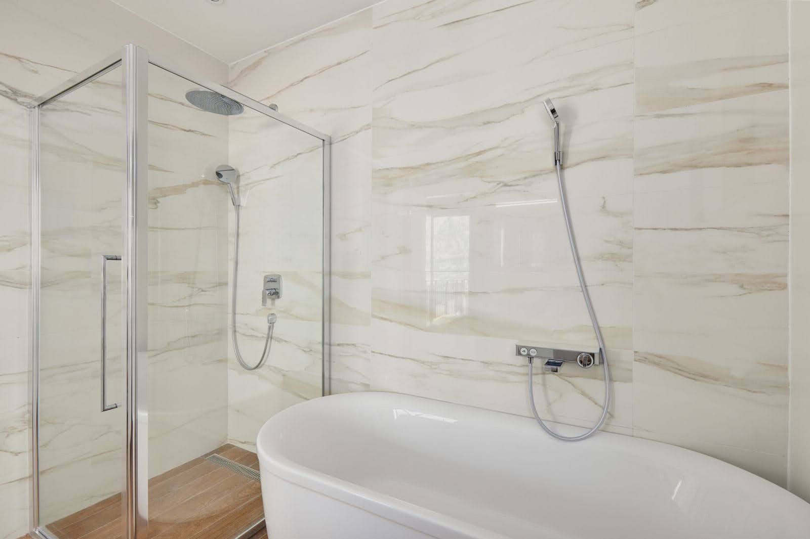 Prčanj, Karadağ’daki villada duş kabini ve ayrı duran küvetli modern banyo.