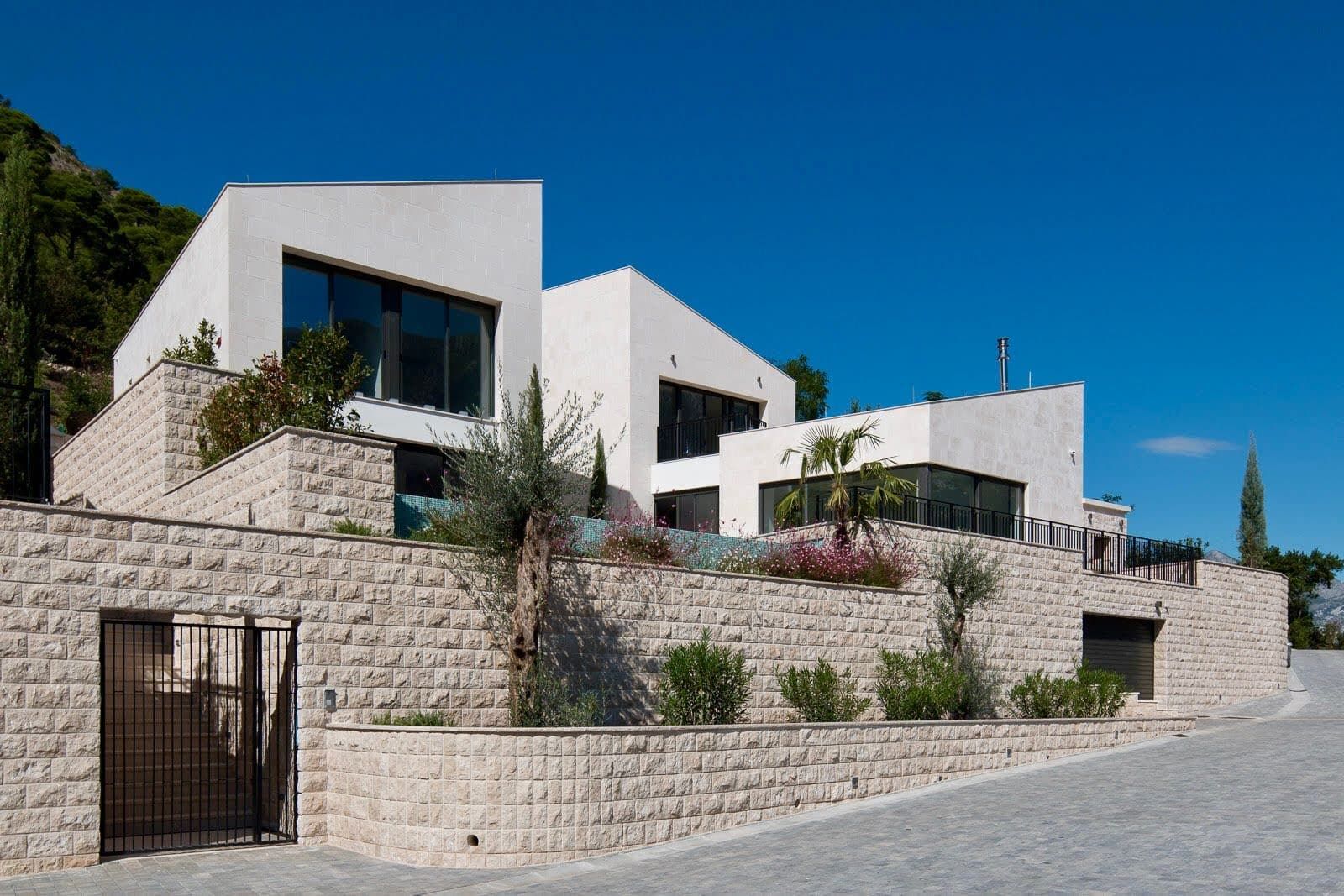 Karadağ, Prčanj’de modern villa: doğal taş cepheli, panoramik pencereli ve havuzlu teraslı.