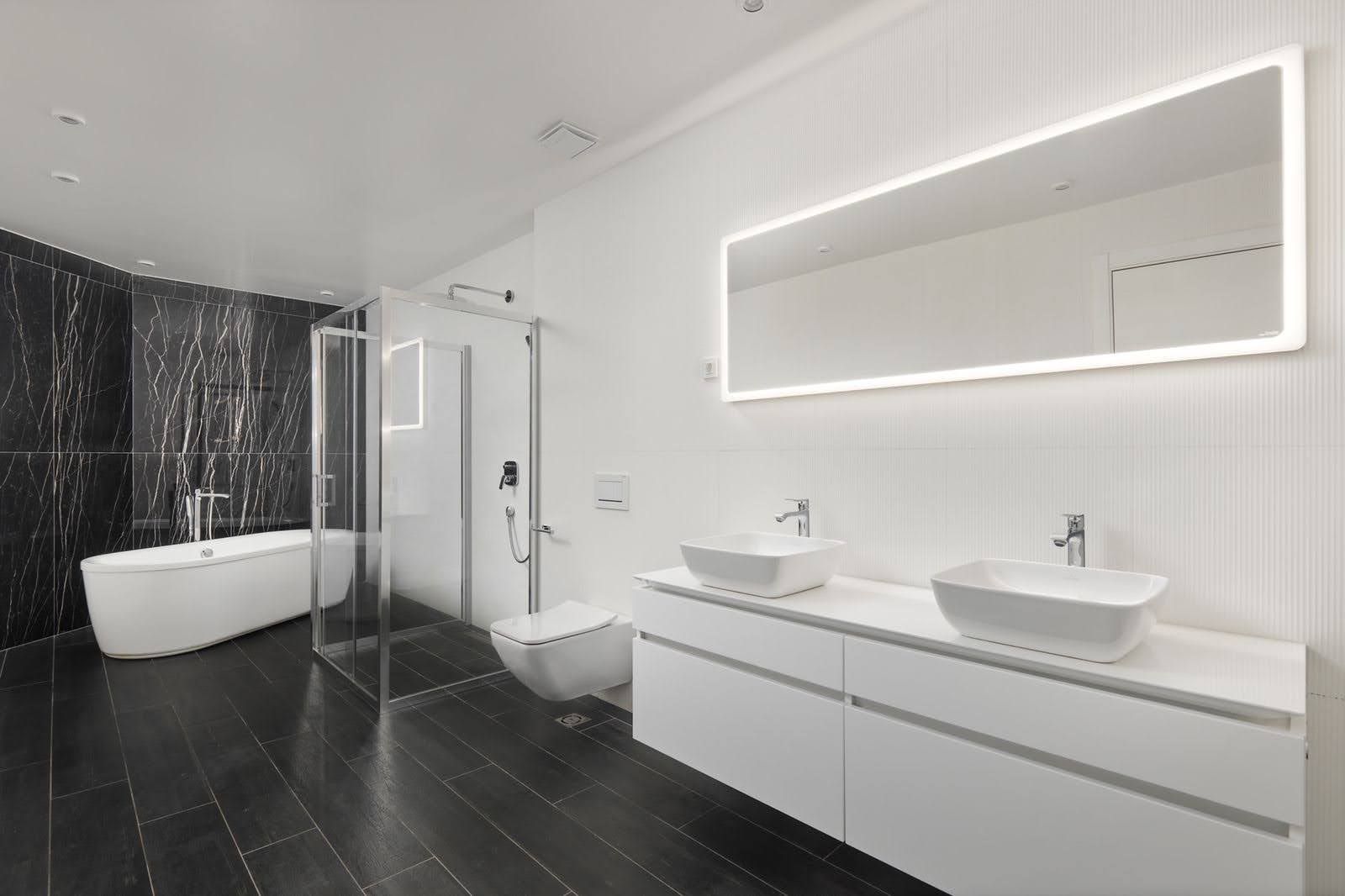 Karadağ, Prčanj’deki villada modern banyo: siyah fayans, bağımsız küvet ve çift lavabo.