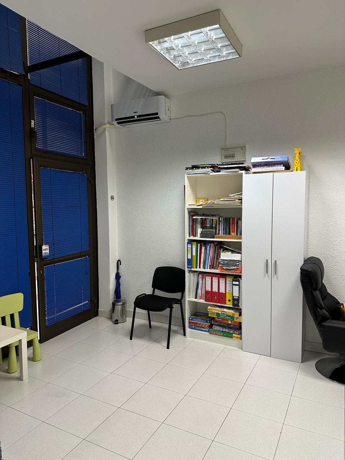 Büroraum in Bar, Montenegro: heller Arbeitsraum mit weißem Schrank, Regal, Klimaanlage und Panoramatür.