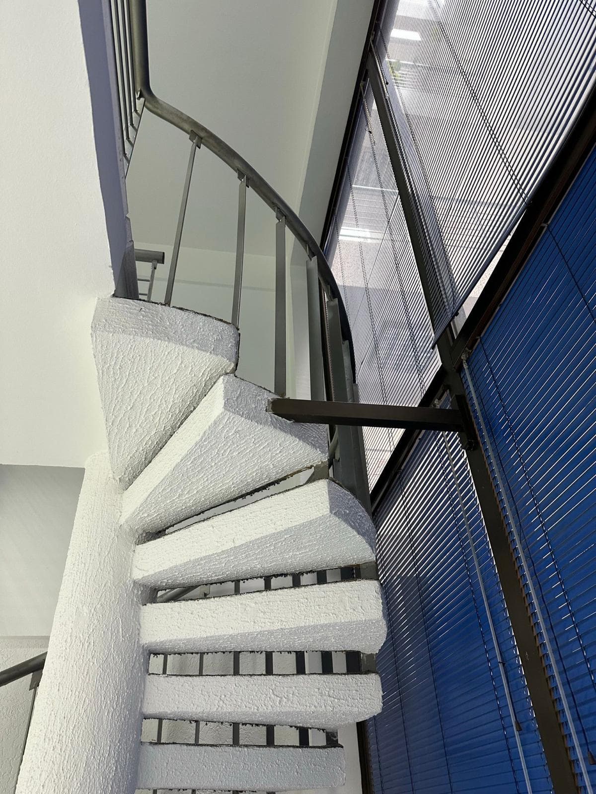 Weiße Wendeltreppe in einem modernen Büro, Stadt Bar, Montenegro, Panoramaverglasung mit Jalousien.