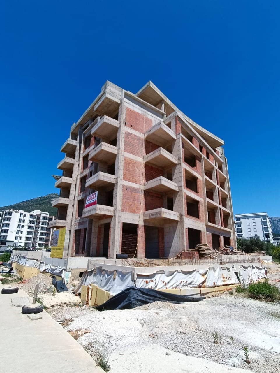 Immeuble collectif en briques en construction avec balcons à Šušanj, Monténégro. Vente immobilière sur plan.