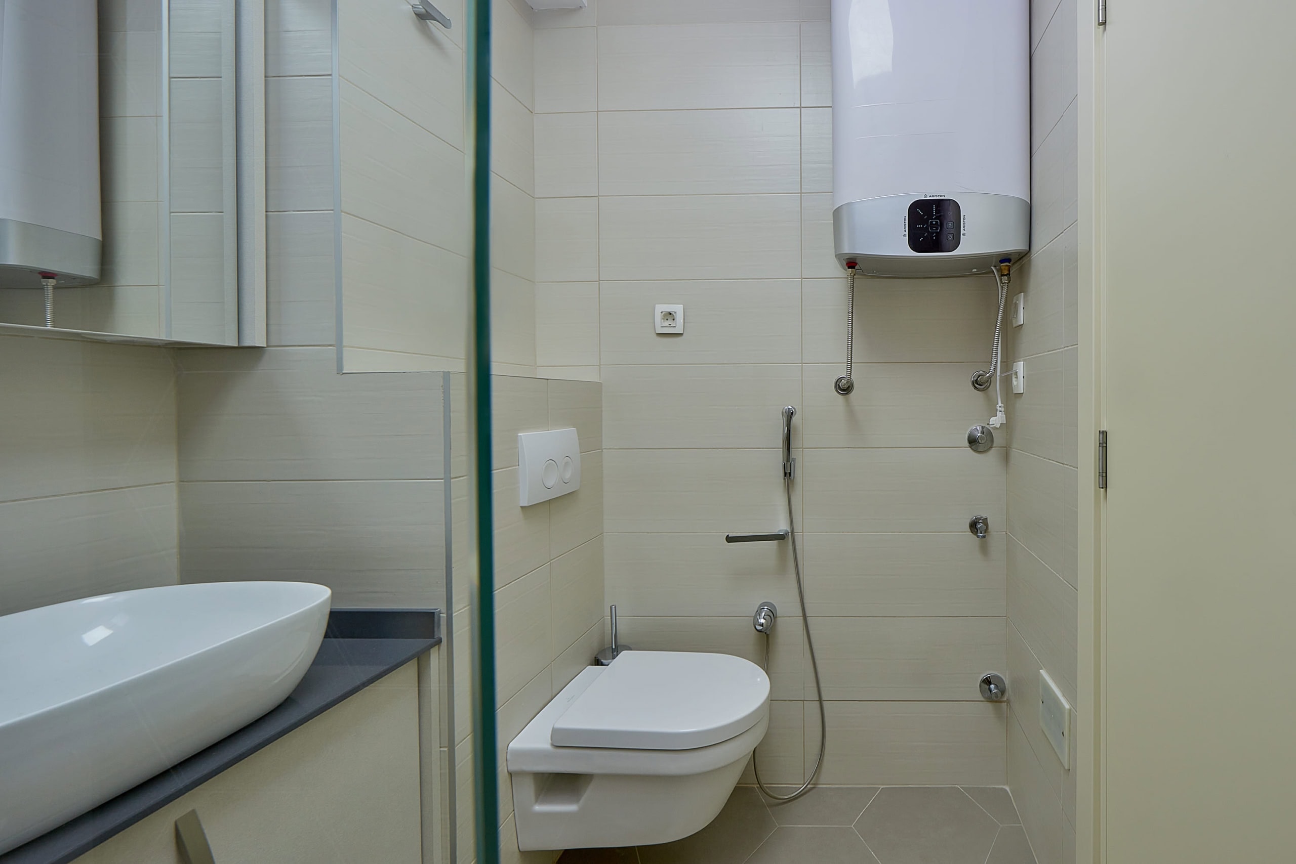 Modern bathroom in an apartment, Dobrota, Montenegro: wall-mounted toilet, bidet shower, and Ariston water heater.