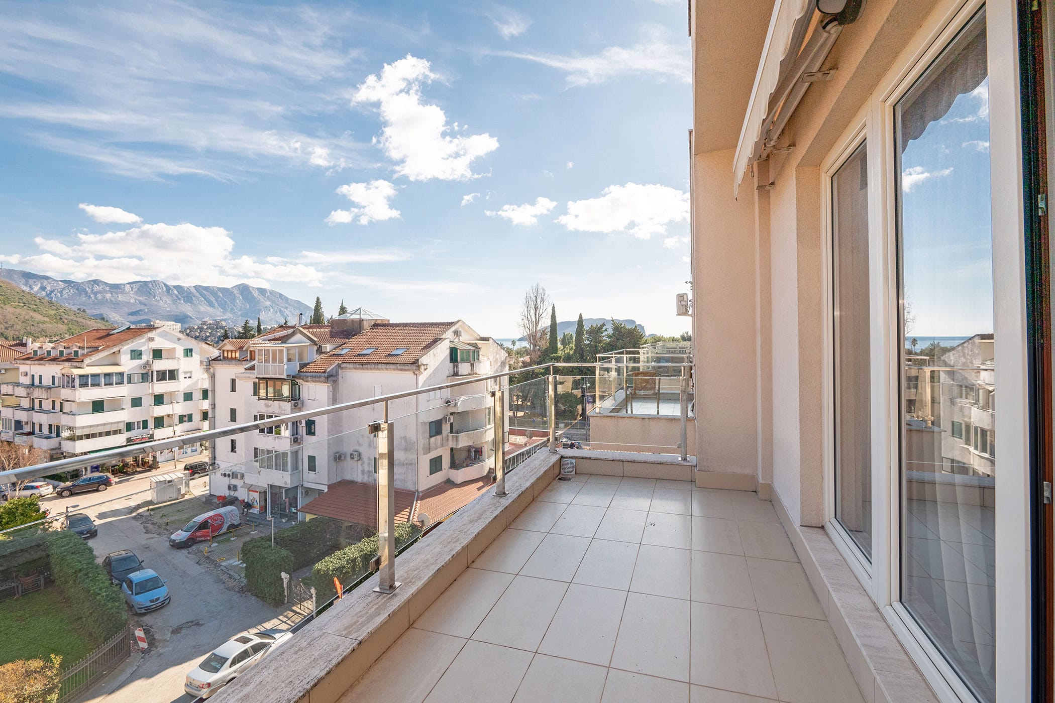 Geräumiger Balkon mit Panoramablick auf die Stadt, die Berge und das Meer in einer Wohnung in Budva, Montenegro.