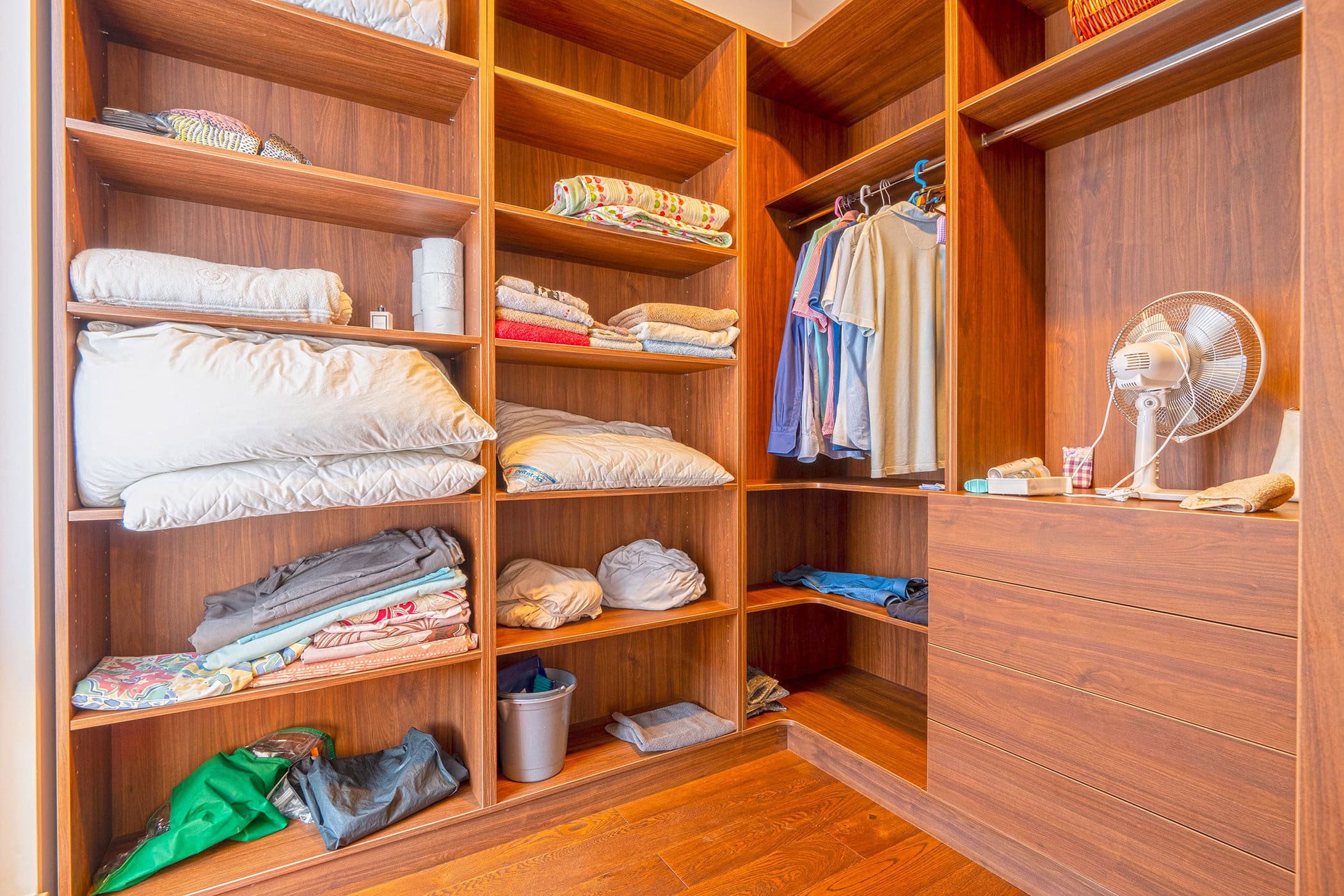 Geräumiger hölzerner Ankleideraum mit Regalen und Kleiderstangen in einer Wohnung in Budva, Montenegro.