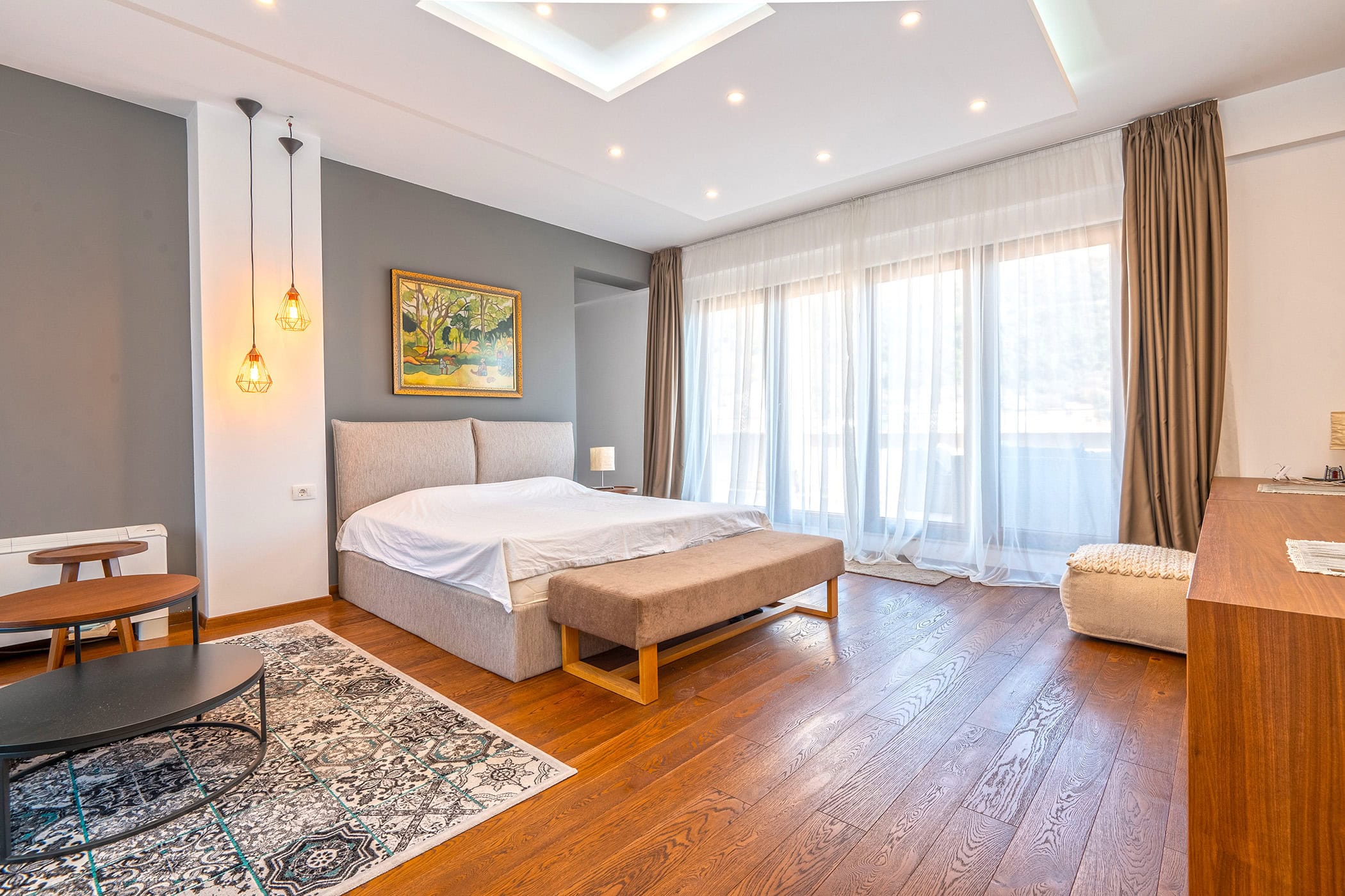 Modernes Schlafzimmer in einer Wohnung in Budva, Montenegro: Doppelbett, Panoramafenster und stilvolles Interieur.
