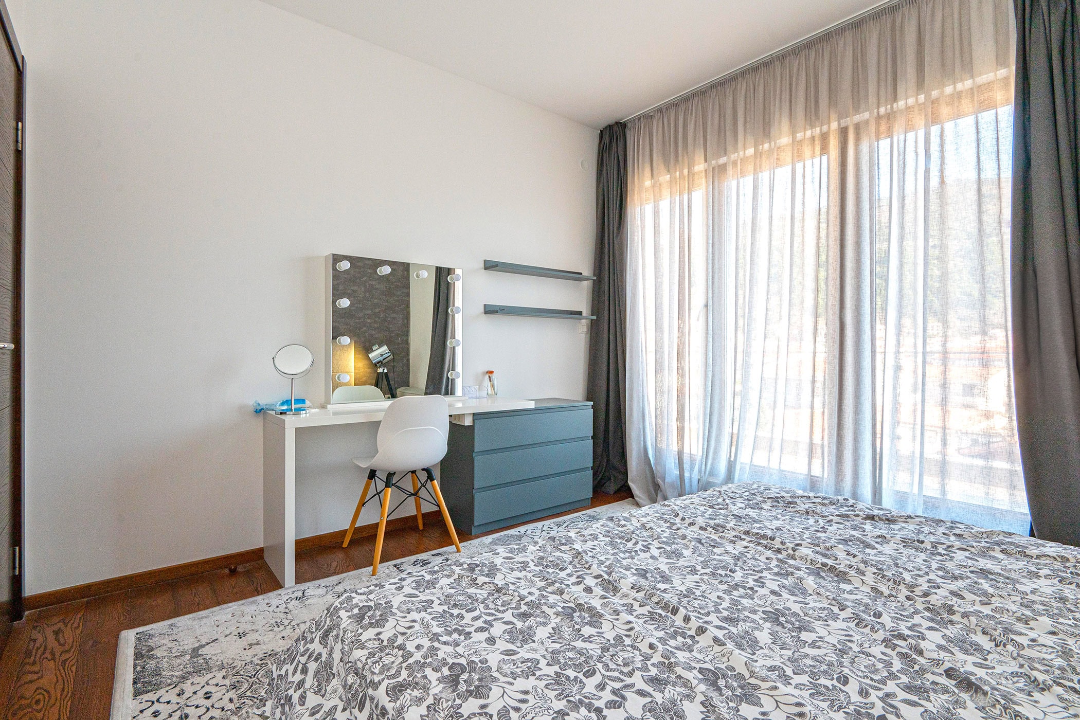 Modernes Schlafzimmer mit Schminktisch und Panoramafenster in einer Wohnung in Budva, Montenegro.