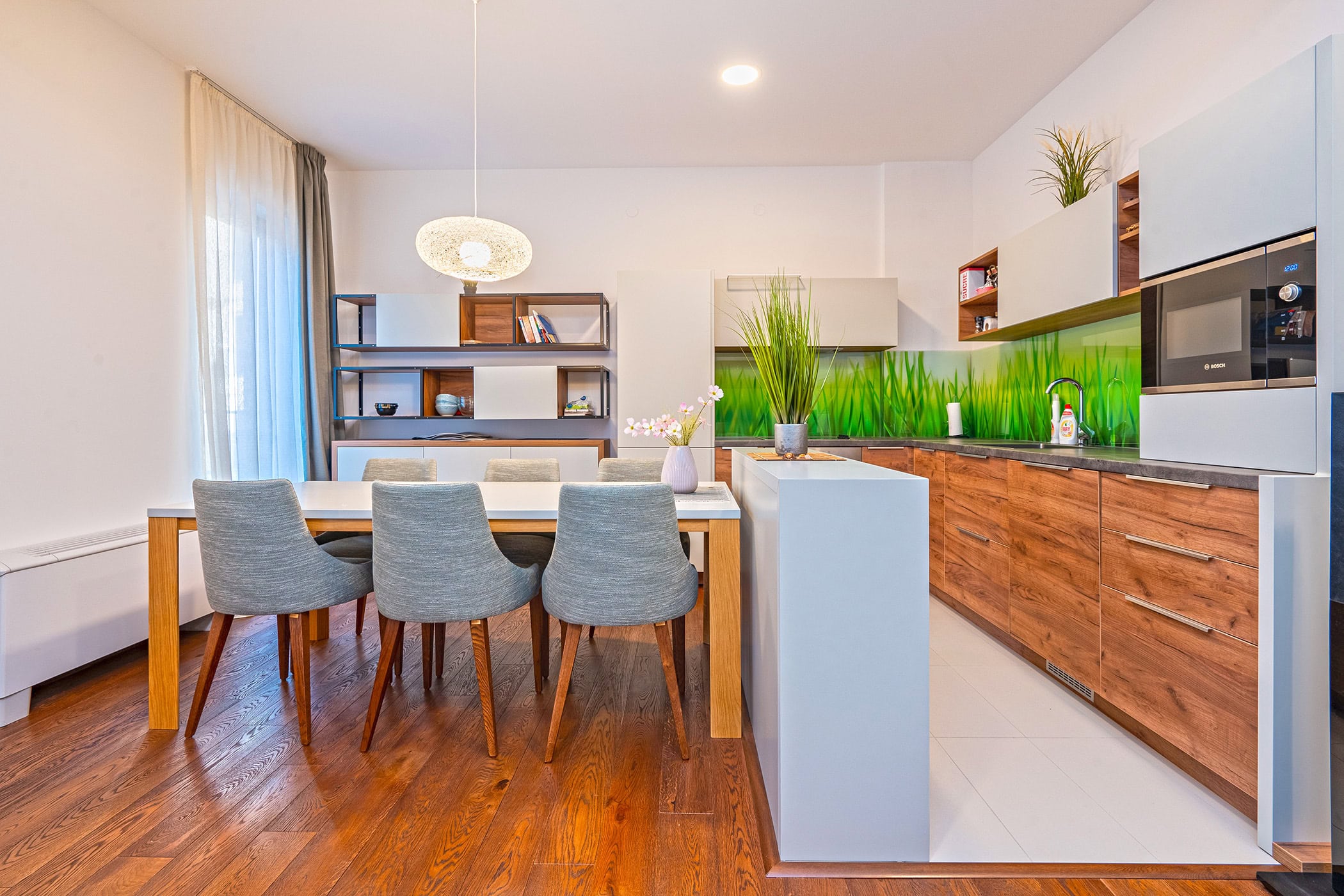 Moderne Wohnküche in einer Wohnung in Budva, Montenegro: Holzfronten, Essbereich und stilvolles Interieur.