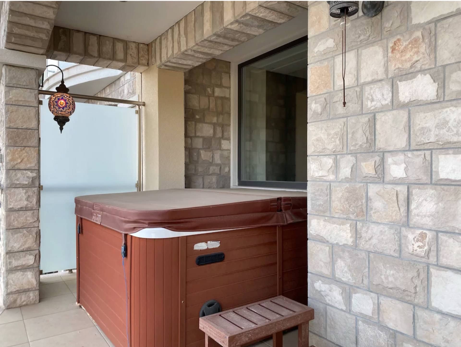 Whirlpool auf der Terrasse der Wohnung in Bečići, Montenegro: Verkleidung aus Naturstein und stilvolle orientalische Laterne.