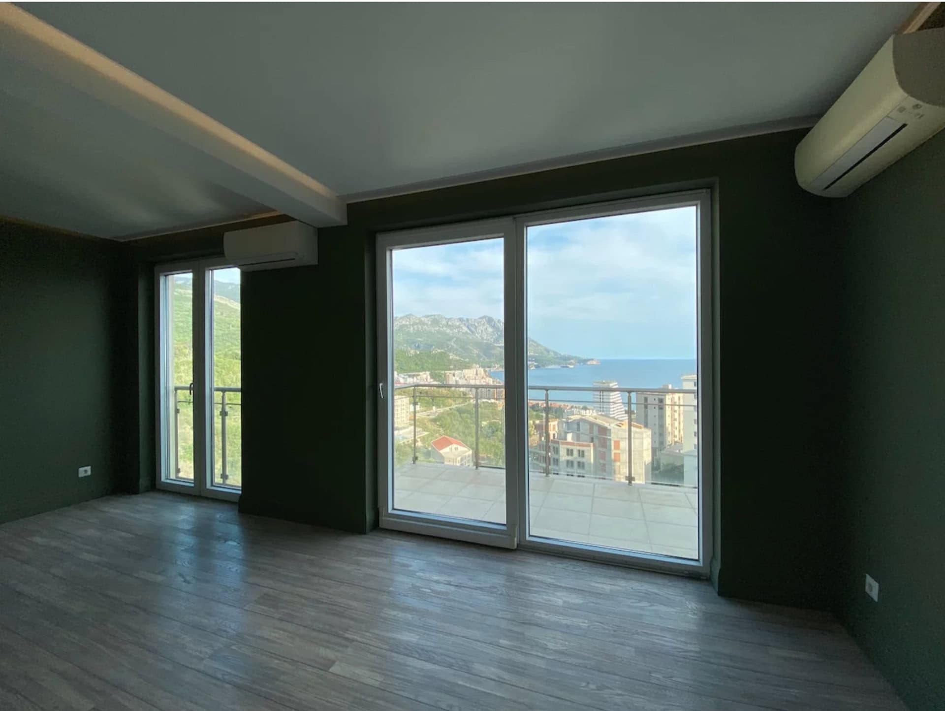 Wohnzimmer mit Panoramafenstern und Meerblick in einer Wohnung, Bečići, Montenegro: moderne Ausstattung und Terrasse.