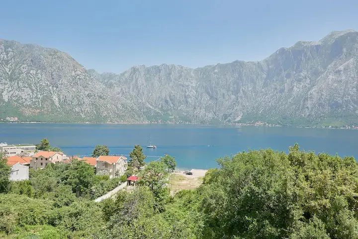 Karadağ, Prčanj’deki daireden Kotor Körfezi ve dağların panoramik manzarası: deniz, yatlar ve yeşil kıyı bölgesi.