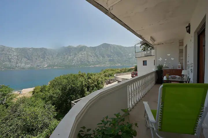 Kotor Körfezi ve dağlara panoramik manzaralı balkon, Prčanj, Karadağ: bahçe mobilyalı teras.