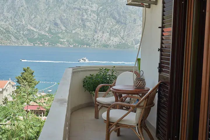 Karadağ, Prčanj’de Kotor Körfezi ve dağlara panoramik manzaralı, hasır mobilyalı balkon.