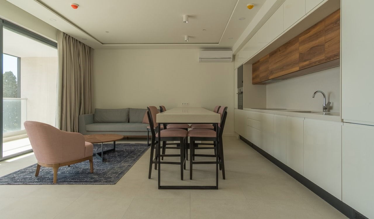Moderne Wohnküche mit Möbeln, Panoramafenster und Essbereich in einer Wohnung in Bečići, Montenegro