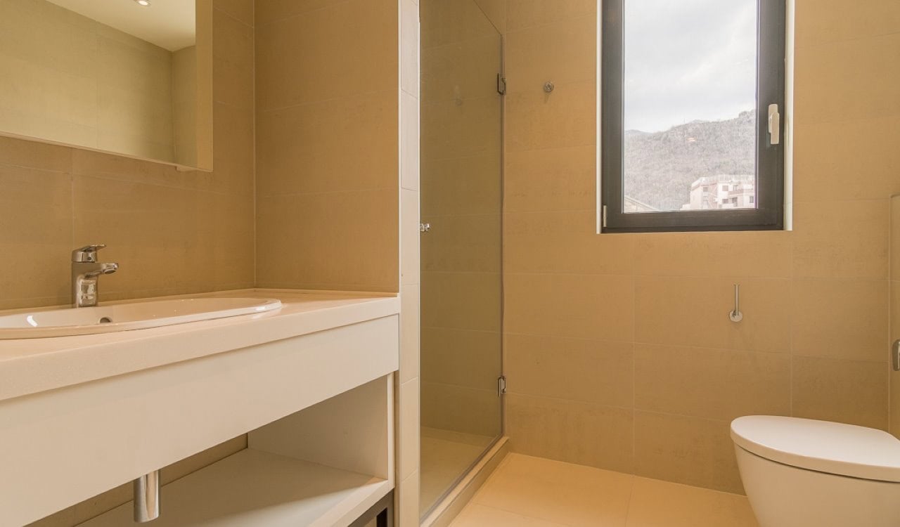 Modernes Badezimmer mit Dusche und Waschbecken in einer Wohnung in Bečići, Montenegro