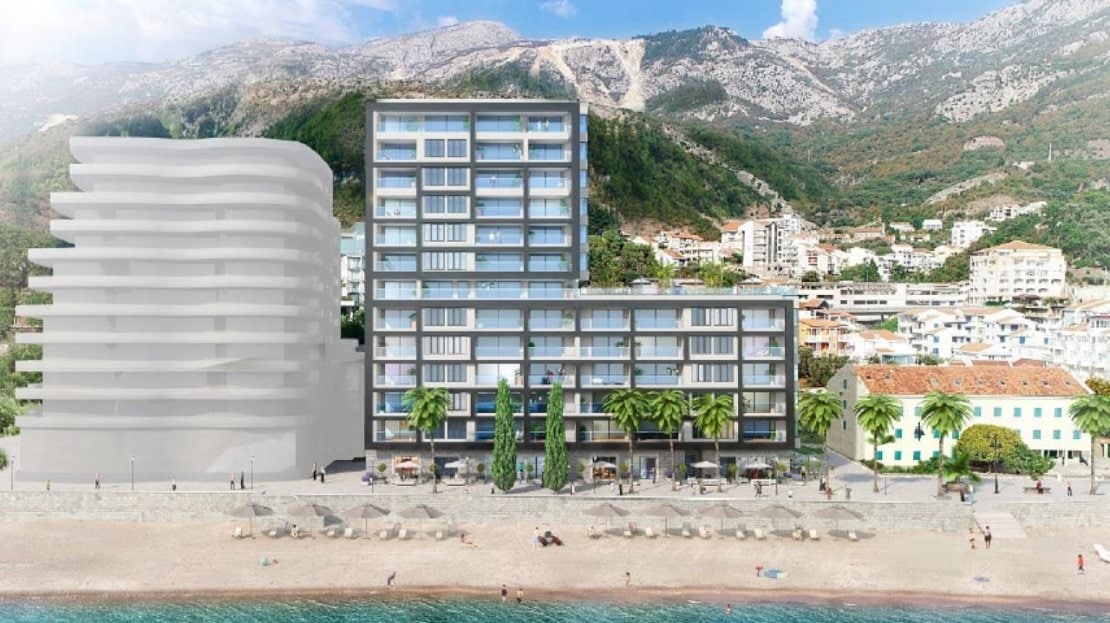 Moderner Wohnkomplex am Strand in Bečići, Montenegro, mit Panoramabalkonen und Bergblick.