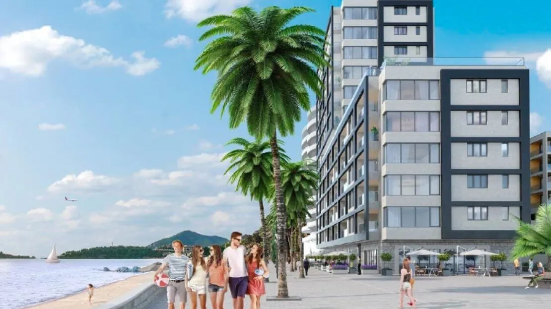 Modern residential complex by the sea with palm trees and a promenade in Bečići, Montenegro