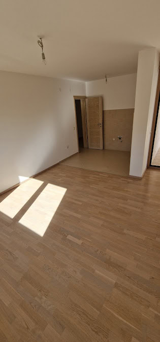 Helles Wohnzimmer mit Parkett in einer neuen Wohnung in Bečići, Budva-Riviera, Montenegro, vorbereitet für den Ausbau.