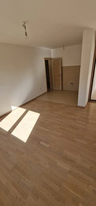Bright living room with parquet in a new apartment in Becici, Budva Riviera, Montenegro, prepared for finishing.