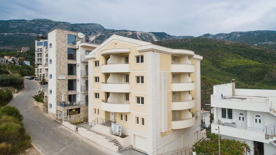 Modern residential complex with balconies in Becici, Budva Riviera, Montenegro: view of the building and mountains.