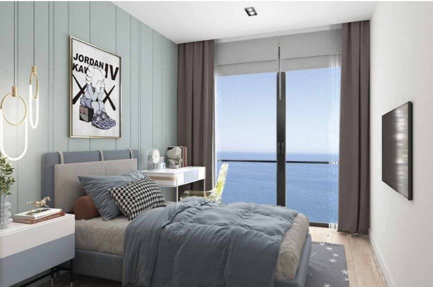 Modernes Schlafzimmer mit Meerblick in einer Wohnanlage in Bar, Montenegro: Doppelbett, Schreibtisch und Panoramafenster.