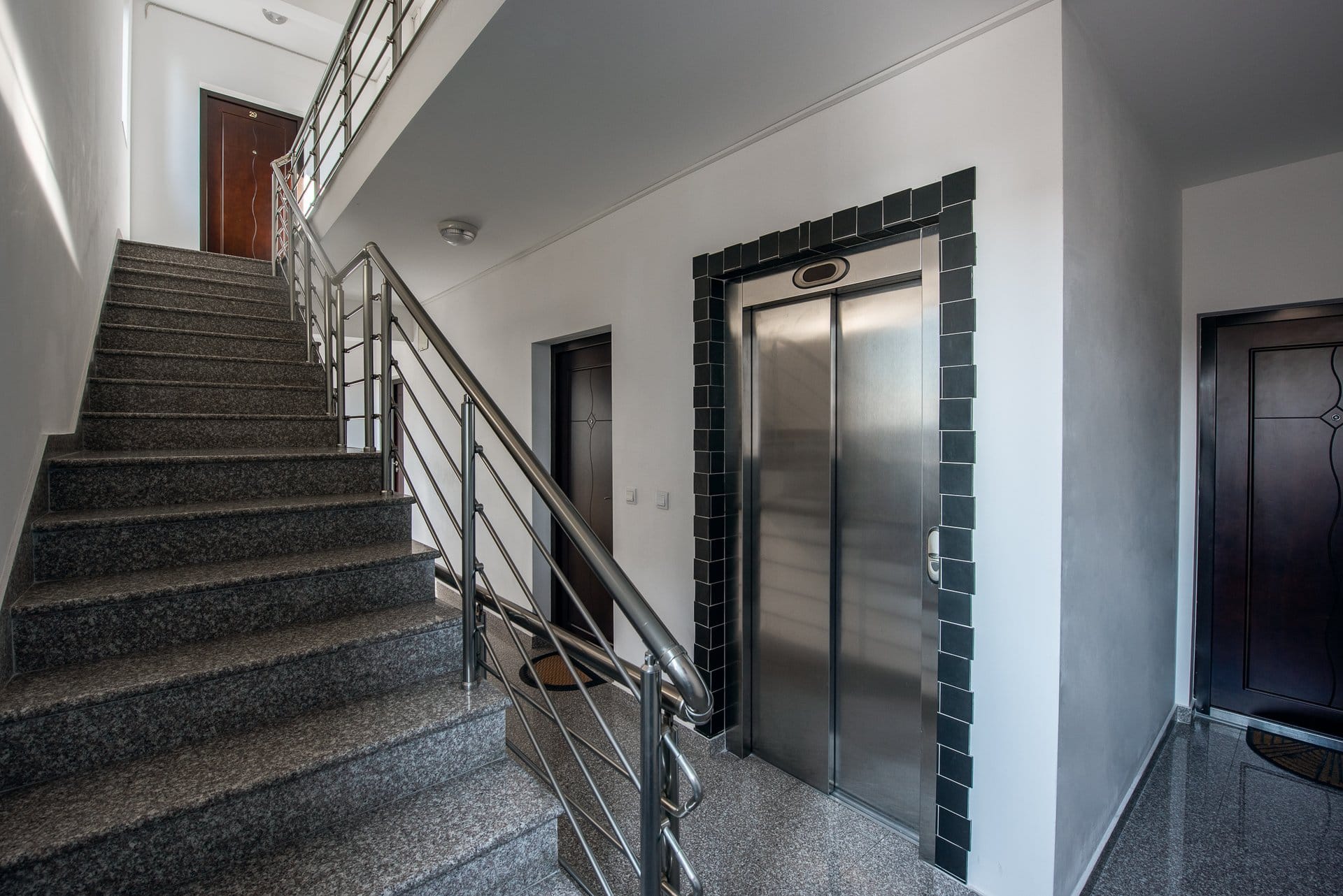 Budva, Karadağ’daki bir konut binasında asansörlü ve granit merdivenli modern giriş.