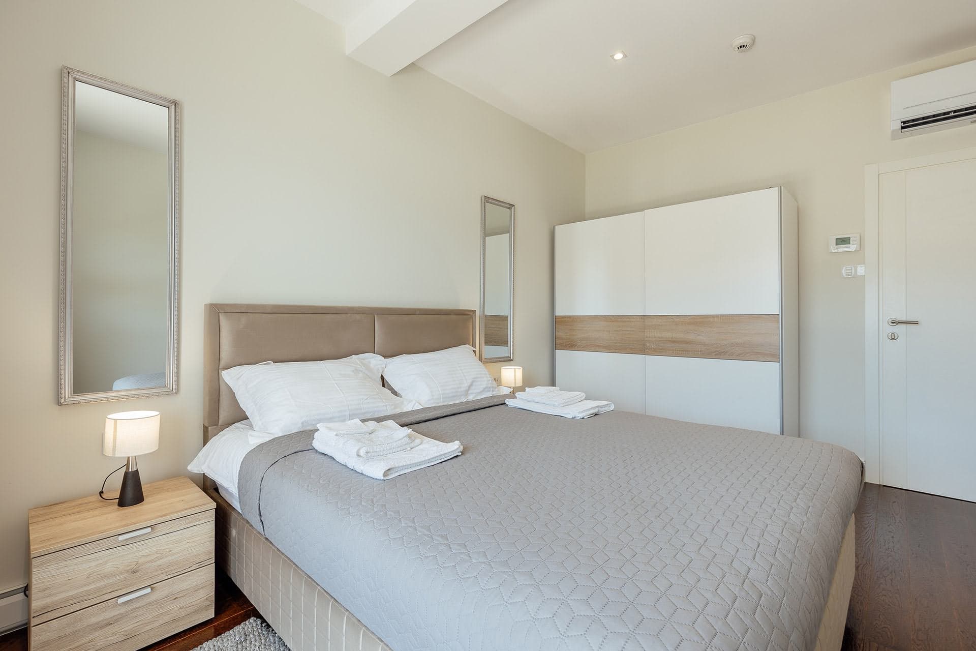 Helles Schlafzimmer mit Doppelbett und Kleiderschrank in der Wohnanlage Kumbor, Montenegro: modernes Interieur und gemütliche Atmosphäre.