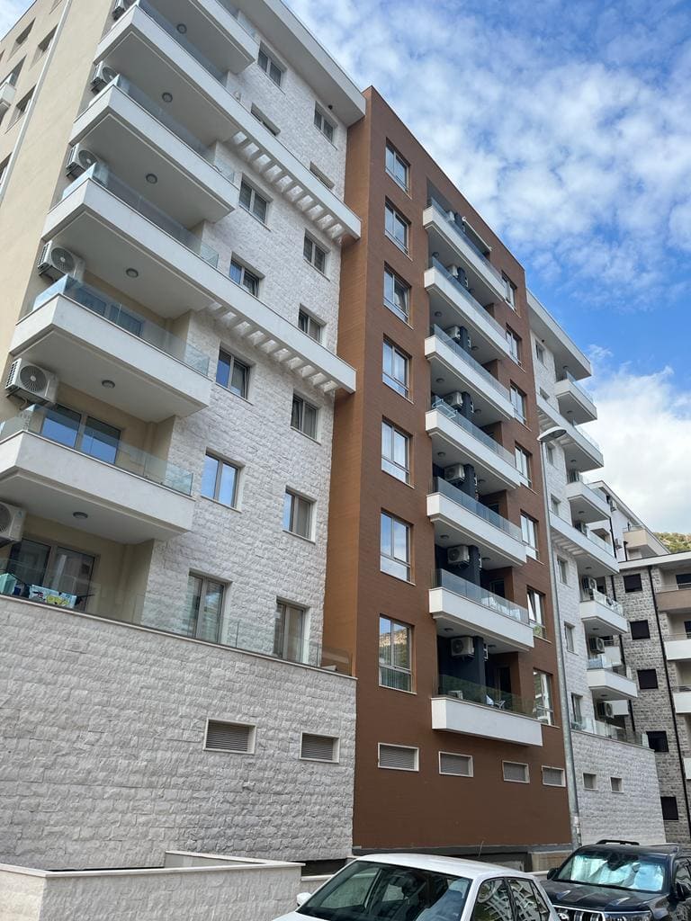 Moderner Wohnkomplex mit Balkonen und Steinverkleidung in Bečići, Montenegro: Blick auf die Fassade des Neubaus.