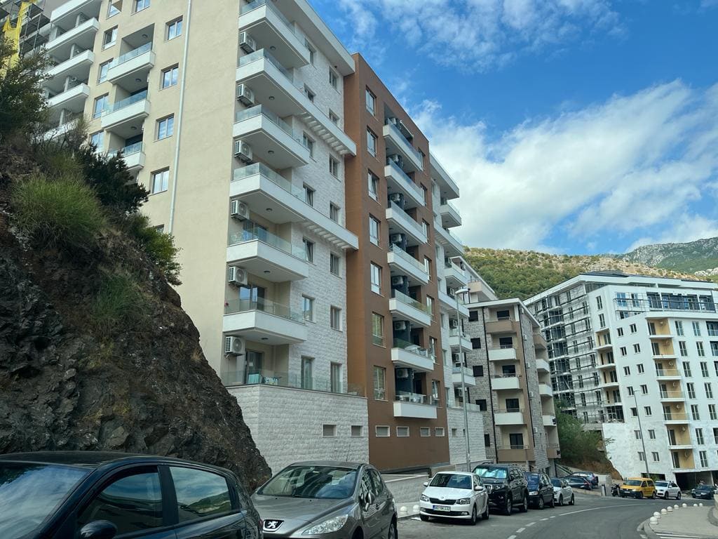 Moderner Wohnkomplex mit Balkonen und Parkplatz in Bečići, Montenegro: Blick auf die Fassade des Neubaus.